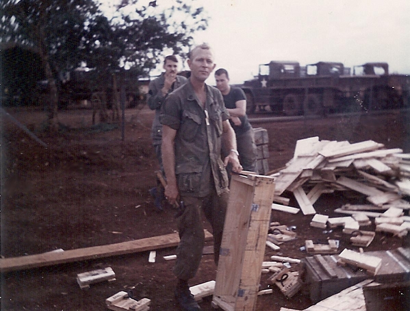 Carpenter in chief
SFC Clyde A. Roker turns ammo boxes into building materials.  His "regular job" was working in the Battalion TOC.  In the rear at left is Jim Castelletti.
