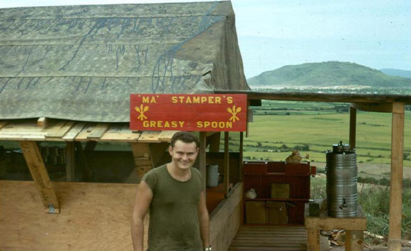 "A" Battery Field Mess Hall
Given the great ingenuity of the battery's cannoneers, a stateside-quality mess hall was built on LZ OD with Sgt Dan Stamper as "Chef in Charge".  Over his shoulder is the 3rd Bde HQ at LZ Montezuma next to the South China Sea at Duc Pho.  The sign says: "Ma Stamper's Greasy Spoon".
