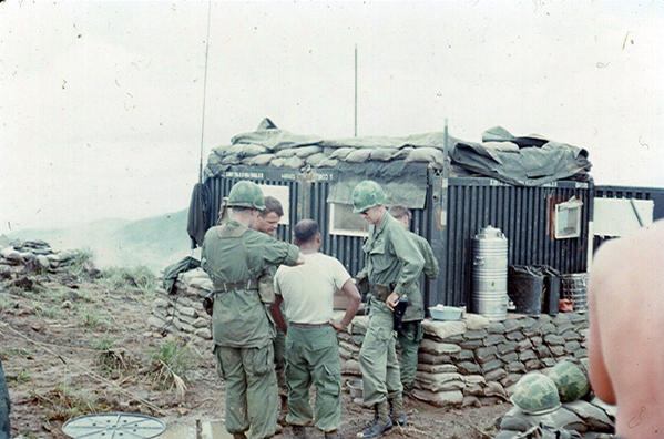 The Final Days: October, 1967  RSOP from LZ OD to Tam Ky
The monsoon lifts; BnCo Bobzien (hands on hips) checks on troops.  White t-shirt: SSG Frank Venegas, Chief of Smoke (deceased); Capt Mike Casp (KIA) in front-left.  Soldier in the rear is likely Lt Malcolm Spencer, who became the new "A"Battery Executive Officer (XO).  The vital FDC CONEX unit was not totally covered in sandbags when the monsoon hit.  If you note carefully, the mud is totally mush.
