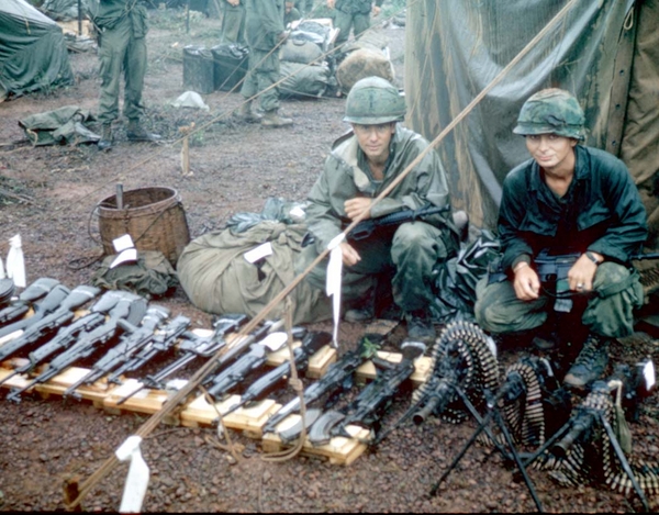 Aftermath of the Battle of Hoa Tan
Forward Observer Lt Don M Keith sits with 2/35th Platoon Leader TJ Blue, (dec 2020) checking out the munitions haul.  It's nice to keep all the weapons on our side.  These are the weapons captured after the battle of Hoa Tan on March 6, 1967.
