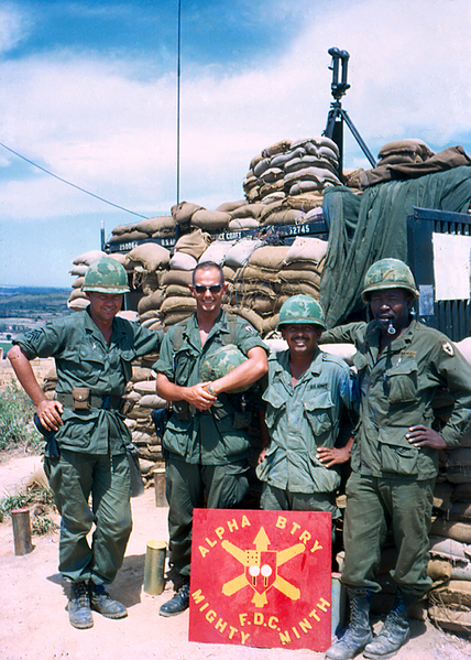 BC Scope atop the sandbagged CONEX aka FDC
1stSgt William Rollins, UNK,  SFC Frank Venegas Chief of Smoke (deceased), CWO Emil Franklin, Bn Radar Officer, standing in front of "A" Battery sign. In back is the heavily sandbagged CONEX serving as a portable FDC.
