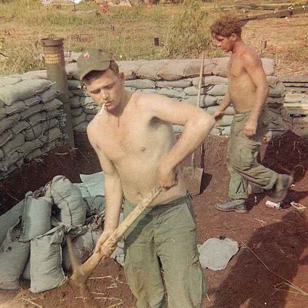 Best Defense
In order to make sandbags, you gotta make mud first.  Sp4 Woodhouse takes a pickaxe to break up the soil.  Note the 2/9th insignia on his field cap.
