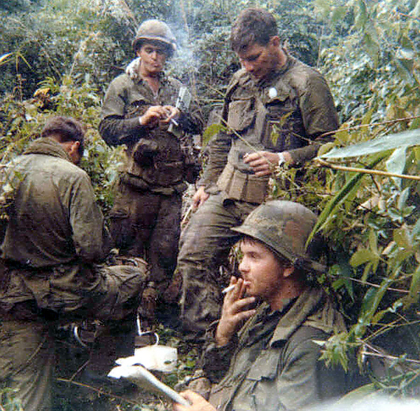Puffing away
Cigarettes were a way of life back then.  FO Lt Joe Hannigan (foreground) plots our location.  You must always know where you are in the jungle.  Lt Hannigan was always on top of his game.  You couldn't ask for a better FO and a nicer guy.  {See next photo: RTO Mike Pskowski was identified in the summer of 2014 by his family who contacted the website.}
