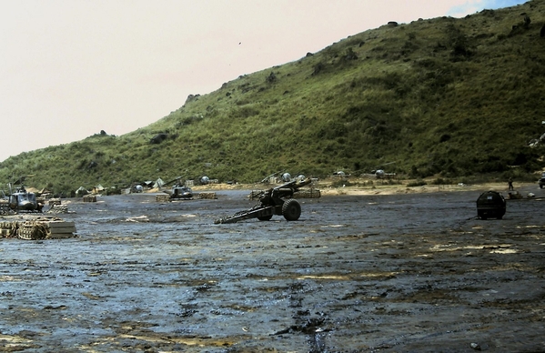 Early Days of Duc Pho - Spring, 1967
A quickly laid spray of asphalt was laid down to control all the dust on the landing pad.  A 155mm howitzer awaits transport to its destination.
