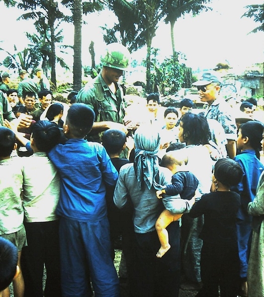 Company Commander shares goodies with the children of a typical Vietnamese village.  Contrary to US news media reports, the children and their parents were glad to see American soldiers.  But they knew the VC would move back in after we left.  It was a never-ending cycle.
