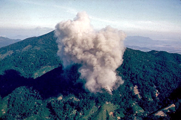 Destroying the caves
The caves found in the Hon Noc mountains were destroyed using loads of TNT.  Smoke rises from one of the explosions.

{Photo courtesy of James Deloney}
