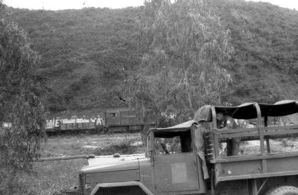 Convoy danger
Traveling highways in VN was always dangerous; the VC often set traps and ambushes.  Note the ancient rail cars in the background.
