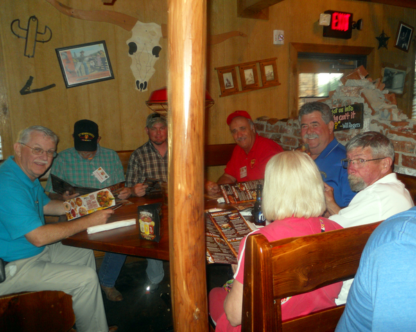 Reunion Photos - Jerry Orr
Off-post chow time.  At left, Ernie Kingcade smiles for the camera, but Cowboy Danny Fort is much more interested in the contents of that menu.  Mike Kurtgis is decked out in the full-red outfit, next to Jim Connolly and M/M Joe Henderson.
