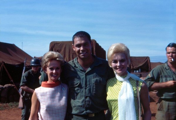 The better times
Actress Tippi Hedren and Diane McBain pose with Sp4 Danny Yates.  Mores smiles.
