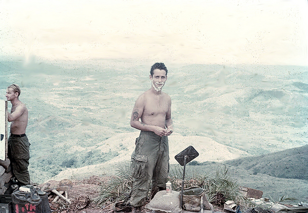 The Final Days
Unk Cannoneer uses a truck mirror to shave high up in the mountains of Tam Ky. At far left, another cannoneer holds the boresight target. On the ground, note the pickaxe and shovel. Tam Ky was my last "duty station" in Vietnam. 
