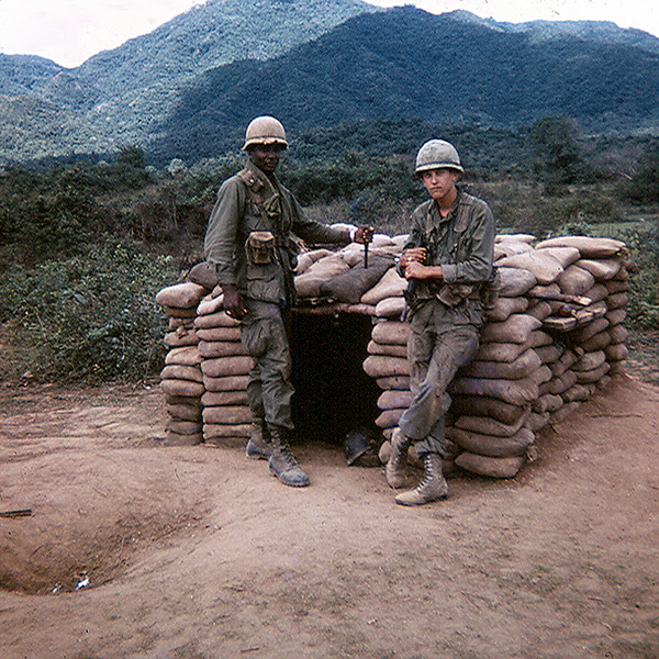 Sgt Fred Carpenter, B-1-35 {KIA} and UNK stand outside bunker a perimeter defense (palace guard) bunker.
