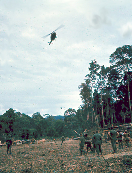 NVA Prisoner
Prisoner enroute.  If you enlarge this photo, you will see just how long the rope is and the prisoner dangling well below the Huey and just above the tree line.
