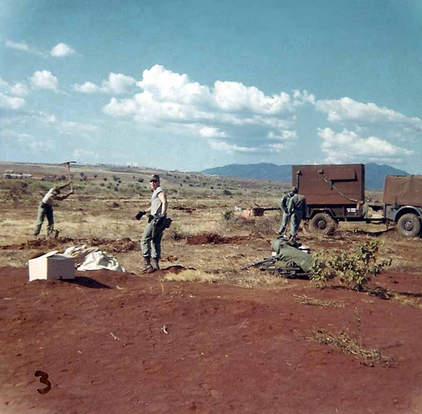 "Base Camp" - Jan 1966
This is our FDC location at Base Camp, Pleiku, 11Jan66.  Sp4 Larry L. Black is half-turned to the camera, Sp4 James McBrayer, Jr is using the pick to make foxholes, Huckaby is by the "Pink Kitty".  The "Pink Kitty" is the FDC training trailer that we brought over from Hawaii.  We decided later that a plywood FDC trailer above ground was not a smart move. The picture is looking north, northwest.

