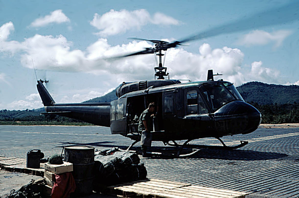 Oh-so-familiar!
Yeah, this may look like just another shot of a Huey, but checking out the foreground, you can tell it is on a resupply run.  There are boxes of C-rats, bundles of sandbags just waiting to be filled, a jerry can and 52-gallon drum.  Maybe this is where UPS got the idea.

