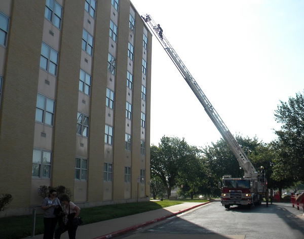Fire Drill: roof of Allin Hall
As we gathered for our first morning activity, the Ft Sill Fire Department gave us a daring sight.  A ladder was extended from the fire truck below to the very top of Allin Hall, our Quarters.  Then, some brave soul climbed that ladder and got a great view of the Fort and surrounding areas.

PHOTO COURTESY OF BOB WILSON

